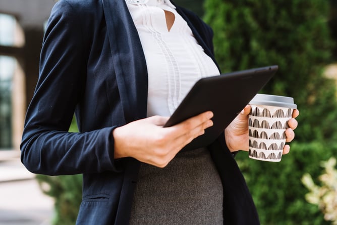 mid-section-businesswoman-holding-digital-tablet-disposable-coffee-cup
